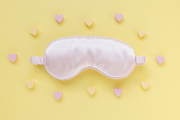 Sleeping mask on yellow background, beauty sleep concept