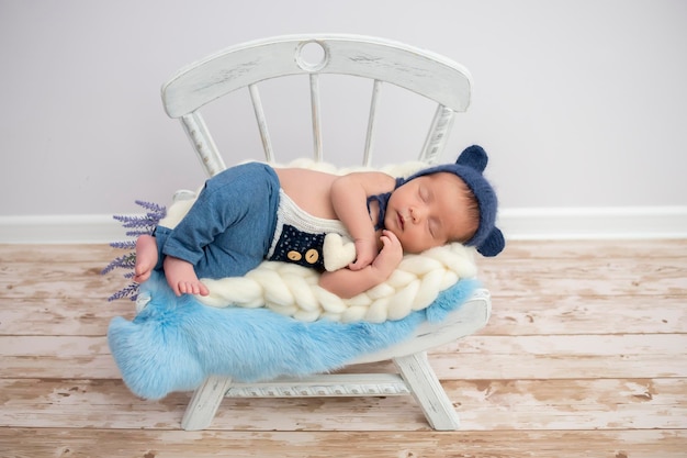 Sleeping newborn baby in basket wrapped in blanket in white fur\
background portrait of little child