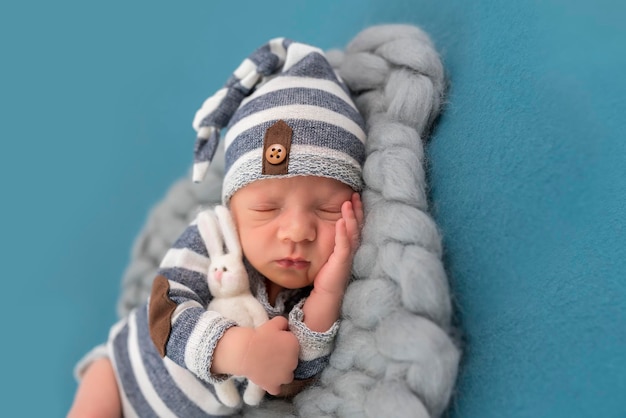 Sleeping newborn baby in basket wrapped in blanket in white fur\
background portrait of little child