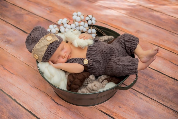 Sleeping newborn baby in basket wrapped in blanket in white fur background Portrait of little child
