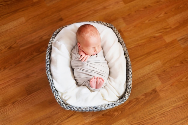 Sleeping newborn baby in a basket