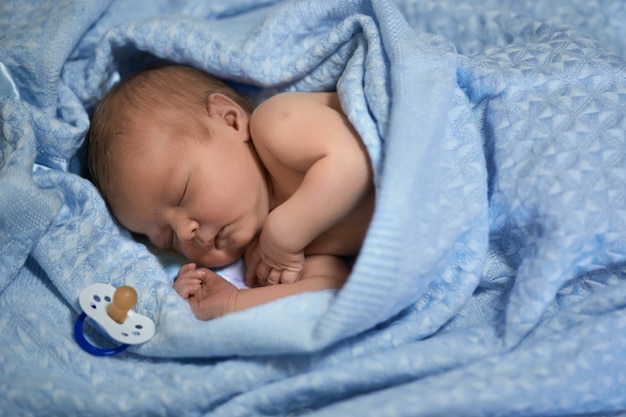 Sleeping newborn baby. Cute little boy 4 days old sleeping without a nipple.