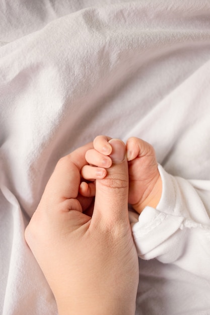 Sleeping newborn baby in a wrap on white blanket