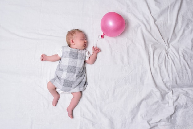 Sleeping newborn girl in a dress. 