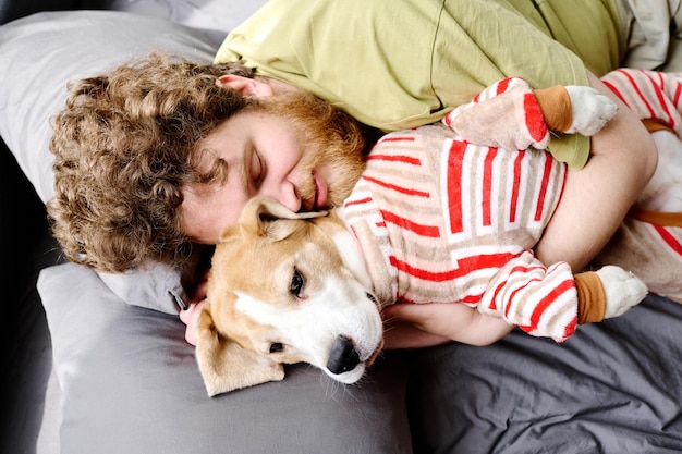 寝室で犬と一緒に眠っている所有者