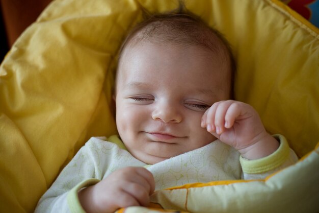 眠っている笑顔の生まれたばかりの赤ちゃん
