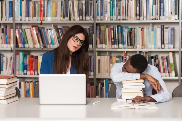 Sleeping Student Sitting And Leaning On Pile Of Books In College  Shallow Depth Of Field