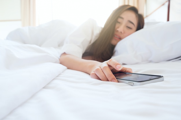 Sleeping Woman Being Woken By Mobile Phone In Bedroom