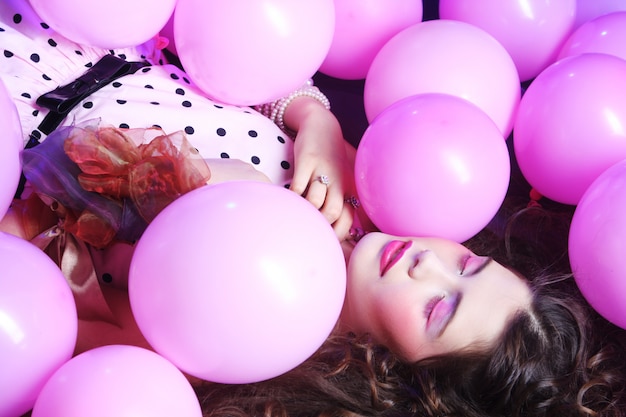 Sleeping  woman lying on floor among balloons