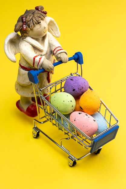 A sleepy Angel carries colorful Easter eggs in a shopping basket