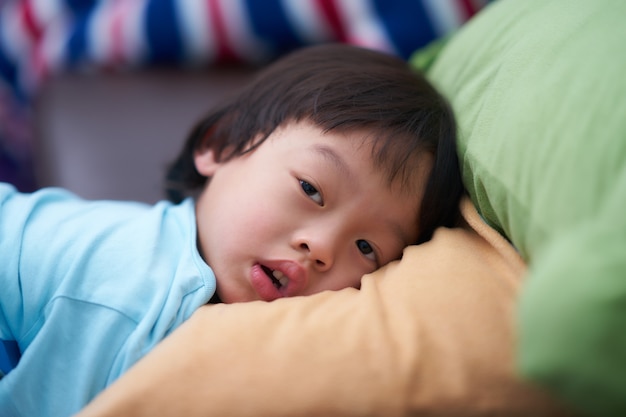 Sleepy boy head lie down on softy pillow with looking