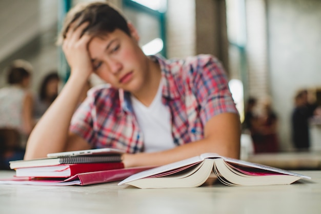 Photo sleepy student posing at table