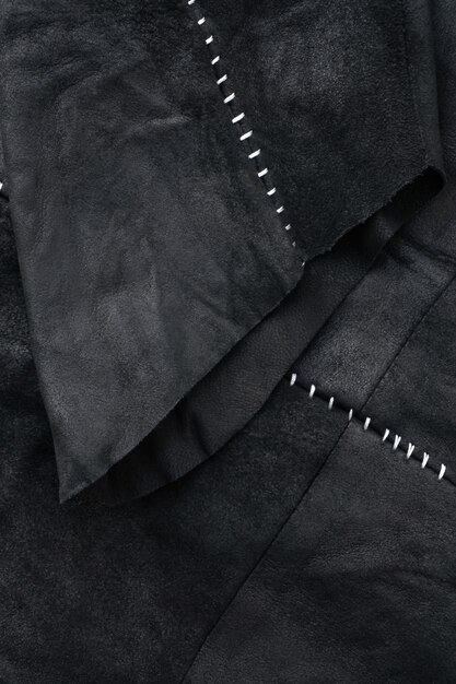 사진 화이트 콘트라스트 스티치가 있는 블랙 스웨이드 재킷의 소매 디테일