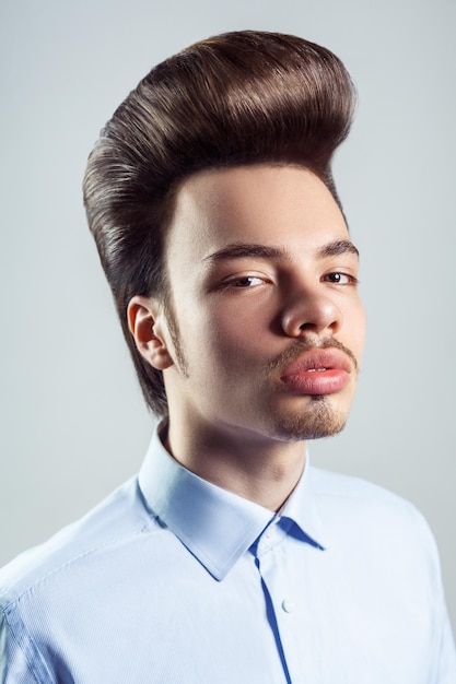 Slelfconfident man met snor met retro pompadour kapsel kijkend met een serieuze uitdrukking