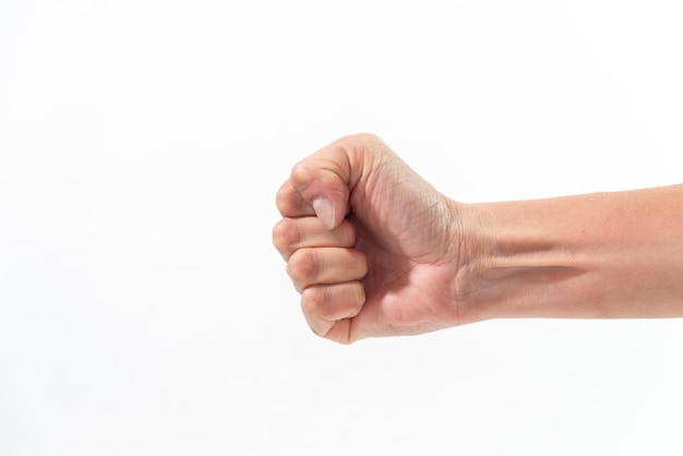 Slender closed fist of woman appearing from left space for copy white background strength