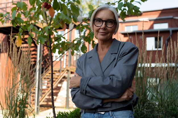 Photo a slender european grayhaired senior business woman with a stylish hairstyle and glasses is dressed