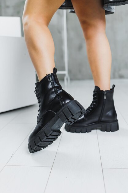 Slender female legs in black winter leather boots Fashionable women's boots Women's leather shoes