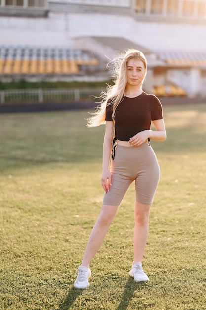 Slender Girl in on a green lawn The concept of going in for sports