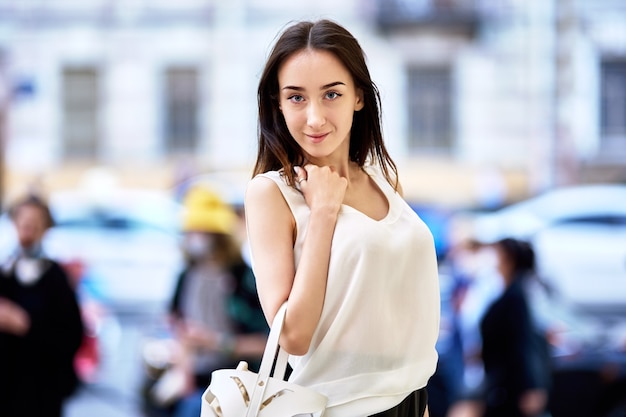 Slender woman with black hair walks in city center