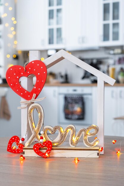 Sleutel tot klein huis van gezellig huis met Valentine decor op tafel van de keuken geschenk voor valentijnsdag familie liefde nest ontwerp project verhuizen naar nieuw huis hypotheek huren en kopen onroerend goed