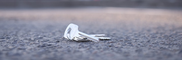 Sleutelbos ligt op de weg in het serviceconcept voor sleutelherstel op de parkeerplaats