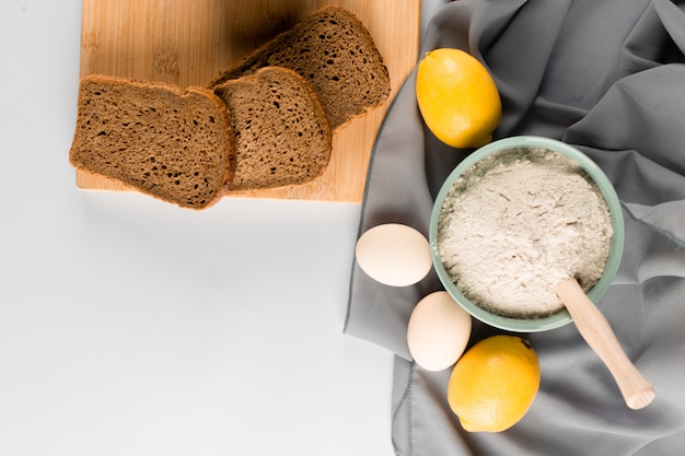 Fetta di pane, farina e uova sul tavolo