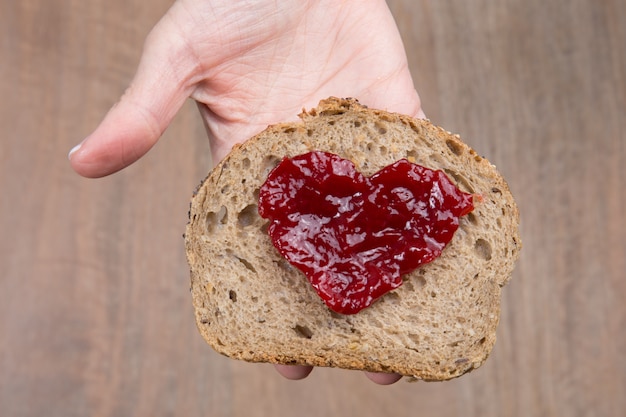 Slice of bread with fruit jam heart shape