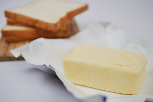 Slice of a butter on a paper on table