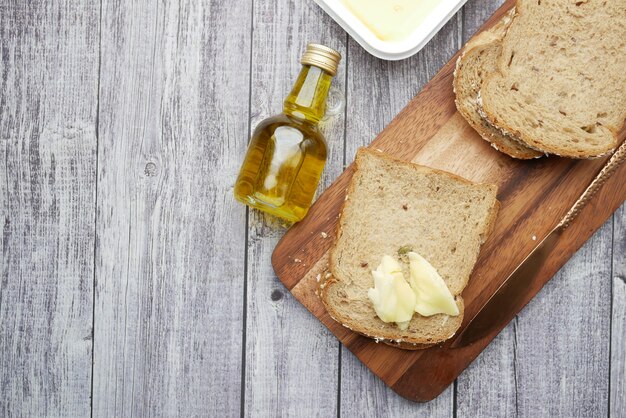 Foto fetta di burro e pane integrale sul tagliere