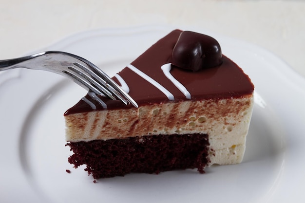 Slice of cake bird39s milk chocolate sponge cake with souffle sweet dessert on a white plate closeup horizontal no people