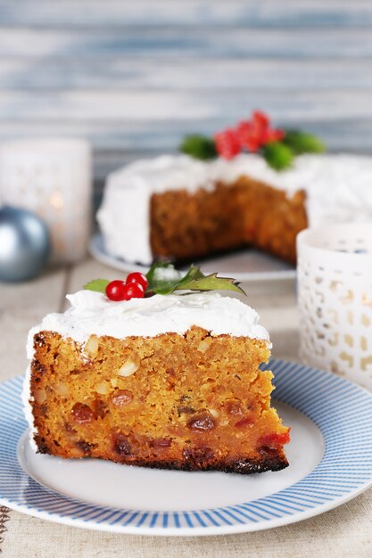 Photo slice of cake on plate with christmas decoration on wooden surface