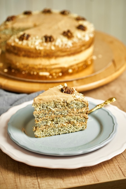 Slice of caramel cake with poppy on plate.