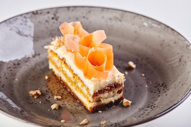 Кусок морковного пирога в тарелке крупным планом на белом фоне