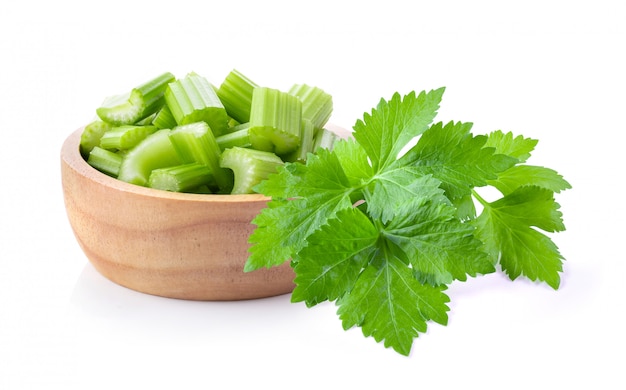 Slice celery in wood bowl isolated on white