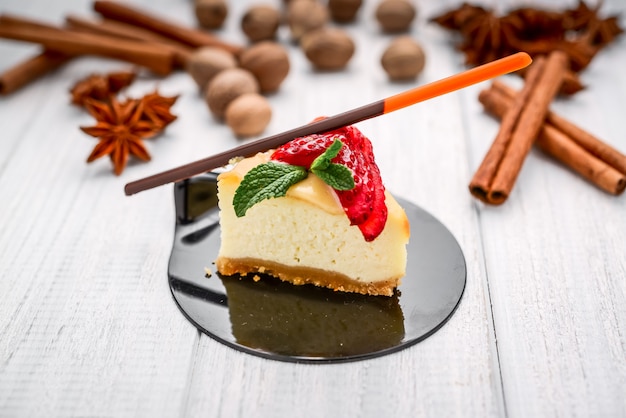 Fetta di cheesecake con frutti di bosco su legno