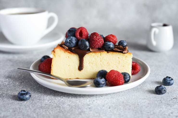 Photo チョコレートソースベリーと一杯のコーヒーとチーズケーキのスライス