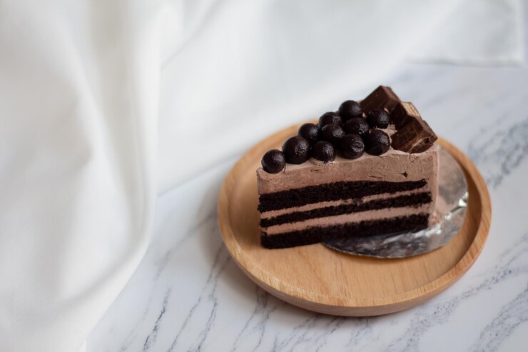 Photo 白い大理石の背景にチョコレートボールが付いたチョコレーツケーキのスライス