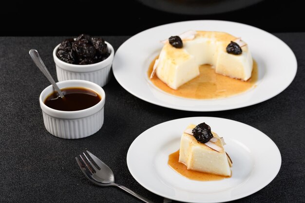 slice coconut blancmange with prune syrup on a white plate