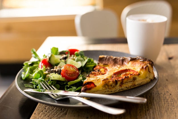 Slice of courgette tart with a salad on a plate