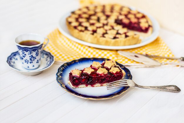 Slice of delicious homemade sour cherry pie on plate.