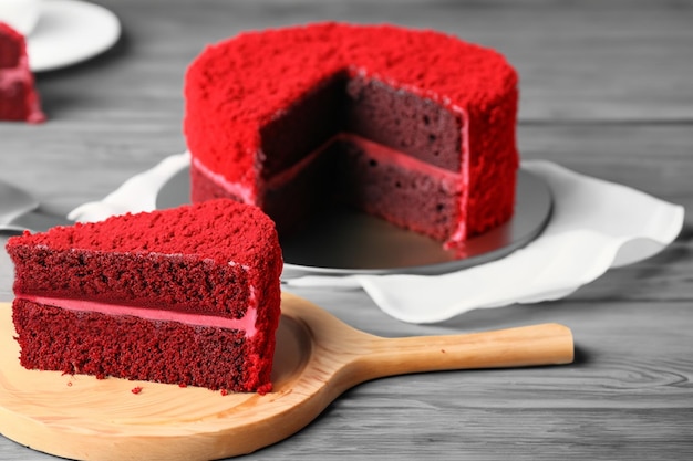 Slice of delicious red velvet cake on wooden stand