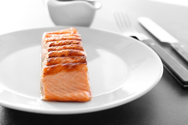 Slice of delicious salmon on plate close up