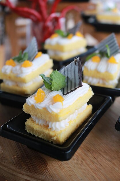 Slice of delicious vanilla cake on wooden table