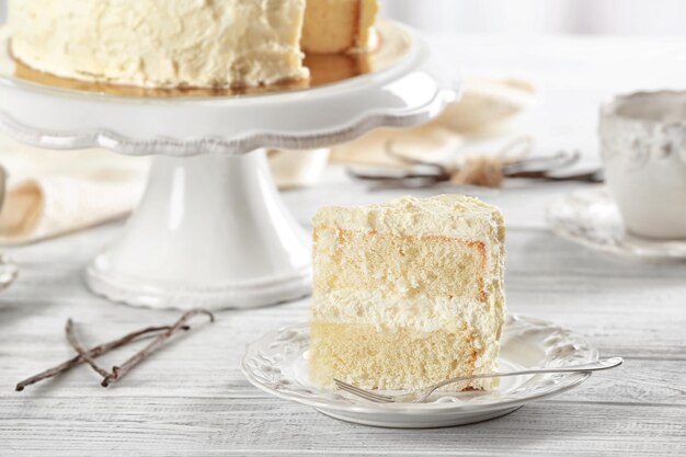 Photo slice of delicious vanilla cake on wooden table