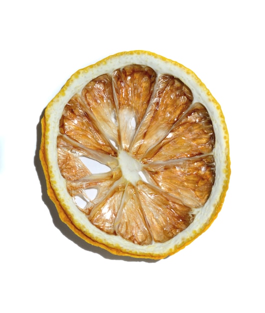 A slice of dried lemon lies on a white background. isolate.