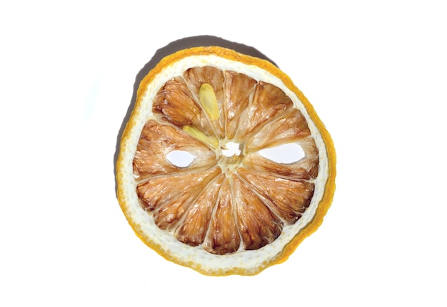 A slice of dried lemon lies on a white background. isolate.