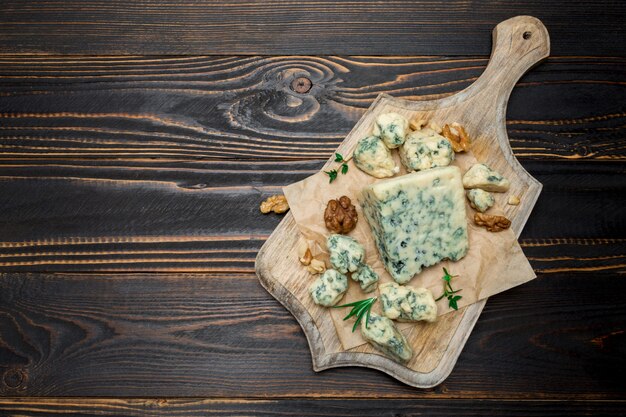 Slice of French Roquefort cheese on wooden board