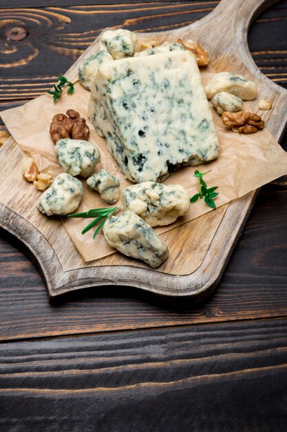 Slice of French Roquefort cheese on wooden board
