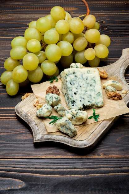 Slice of French Roquefort cheese on wooden board