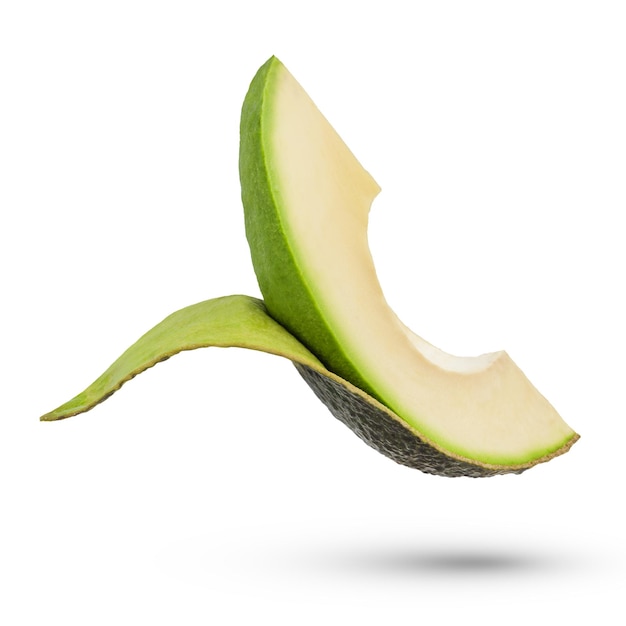 A slice of fresh avocado on a white isolated background A slice of avocado with the skin partially torn away from the pulp The process of peeling avocados on a white background casting a shadow